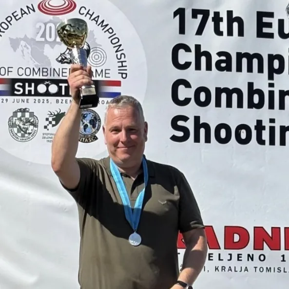 Stefan Geus hält bei der Europameisterschaft im jagdlichen Schießen 2025 den Pokal hoch, um den Hals die Silbermedaille