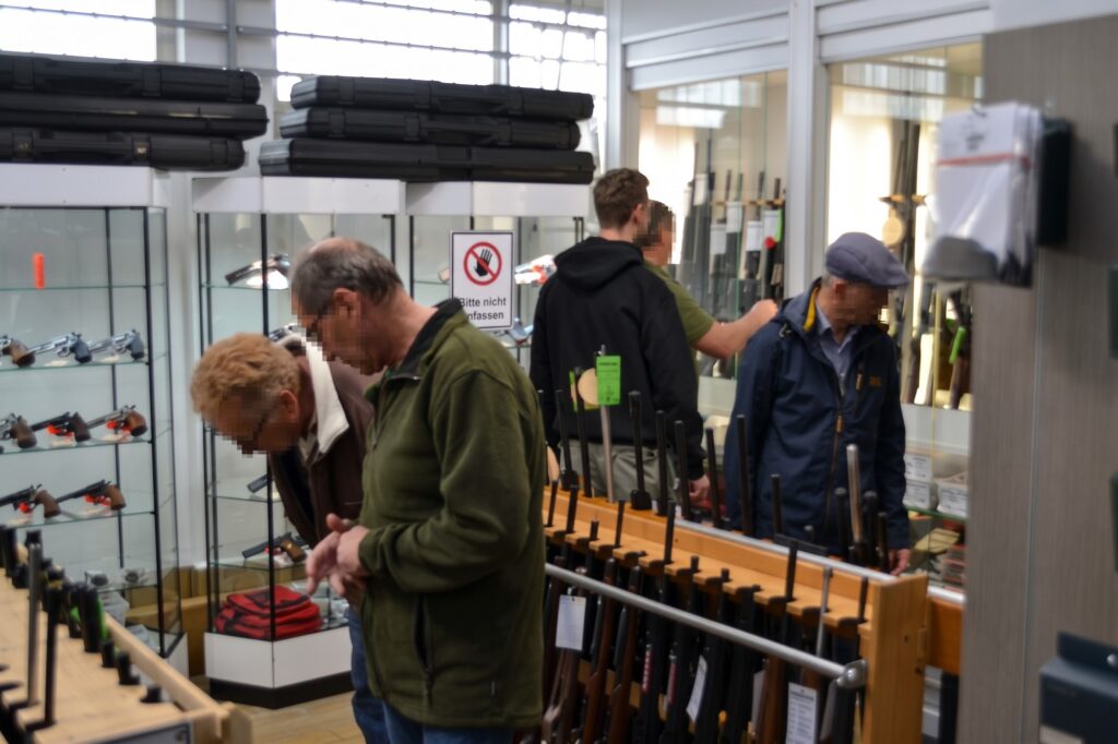 Besucher am Waffenständer im Verkaufsraum.